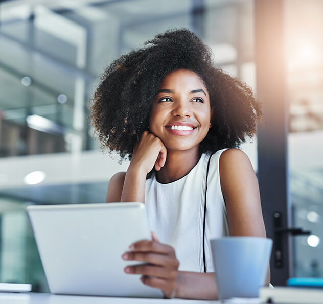 smiling woman sitting in front of a laptop