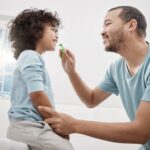father brushing child's teeth to prevent baby tooth fillings and baby teeth cavities