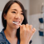 woman brushing her teeth for healthy dental habits